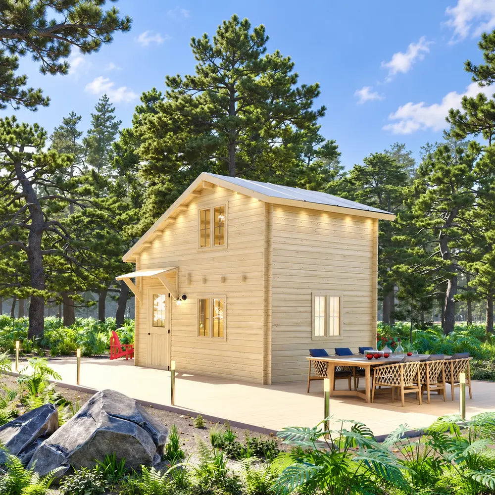 Two-story BlueWater Loft 160 38mm cabin with warm exterior lights, a spacious dining deck, and surrounding pine trees.