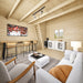 Bright pine interior of the BlueWater Loft 160 with a white sofa, bar seating, cabinet, and ladder to the loft.