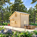 Two-story BlueWater Loft 160 cabin with warm exterior lights and an outdoor dining table on the forest deck.