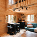 Rustic pine kitchen and sitting area in the BlueWater Loft 160 with black cabinetry, island seating, and a teal chair.
