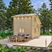 Side view of the BlueWater Loft 160 showing its natural-wood exterior and long dining table on the extended deck.