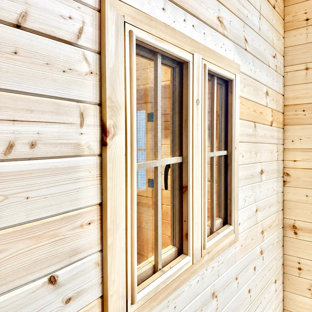 Angled exterior close-up of two screened Bluewater Den 67 windows with detailed wooden framing and a visible black handle.