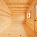 Empty Bluewater Den 67 interior with smooth pine flooring, exposed ceiling beams, a double window and a partially visible wooden door.