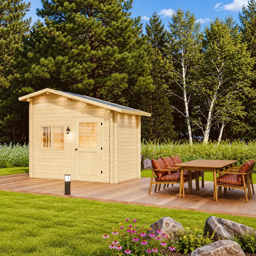 Side-angle view of the Bluewater Den 67 with its sloped roof, wooden deck and outdoor dining area surrounded by trees and flowers.