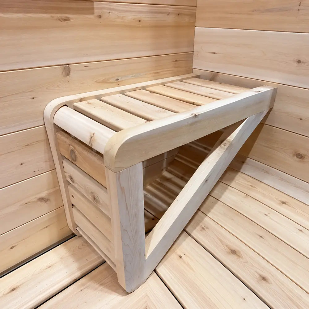 Close-up of the Box Sauna’s pale wooden porch bench with a slatted seat, rounded front edge, and sturdy diagonal support brace.