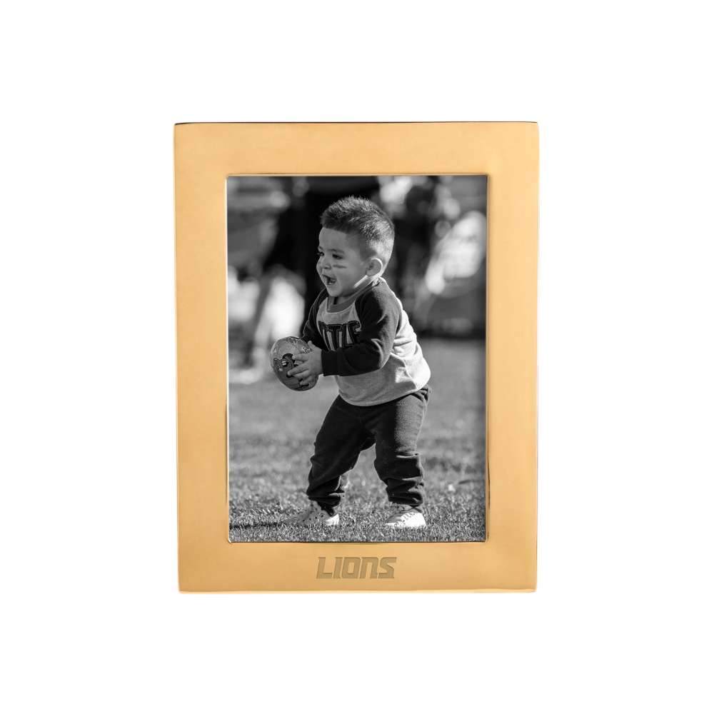 Brass Detroit Lions Crate & Barrel NFL Signature Tabletop Picture Frame with a warm gold-toned frame surrounding a black-and-white image of a young child carrying a football