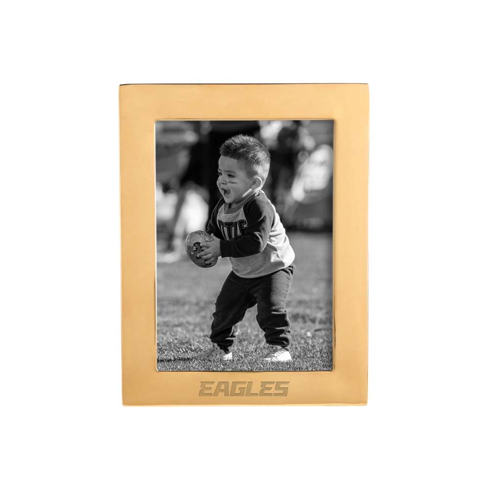 Brass Philadelphia Eagles Crate & Barrel NFL Signature Tabletop Picture Frame featuring a smooth brass finish around a black-and-white image of a young child carrying a football