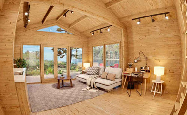 Bright and airy room inside the Sawmill Structures Edwin Lake House PLUS 70MM Garden Room includes a comfy couch, writing desk, and floor-to-ceiling windows
