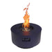 Bright flames shoot upward from a blue Warming Trends AON Steel Circular Fire Pit Table, with the burner and control panel visible