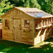 Bright sunlight hits the Outdoor Living Today 12×12 Sunshed Garden Shed, highlighting its five side windows, two front windows, and rustic wood finish