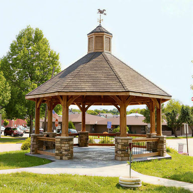 Brookside Timber Frame Lakeside Majestic Pavilion in a park with stone base columns and a spacious covered design