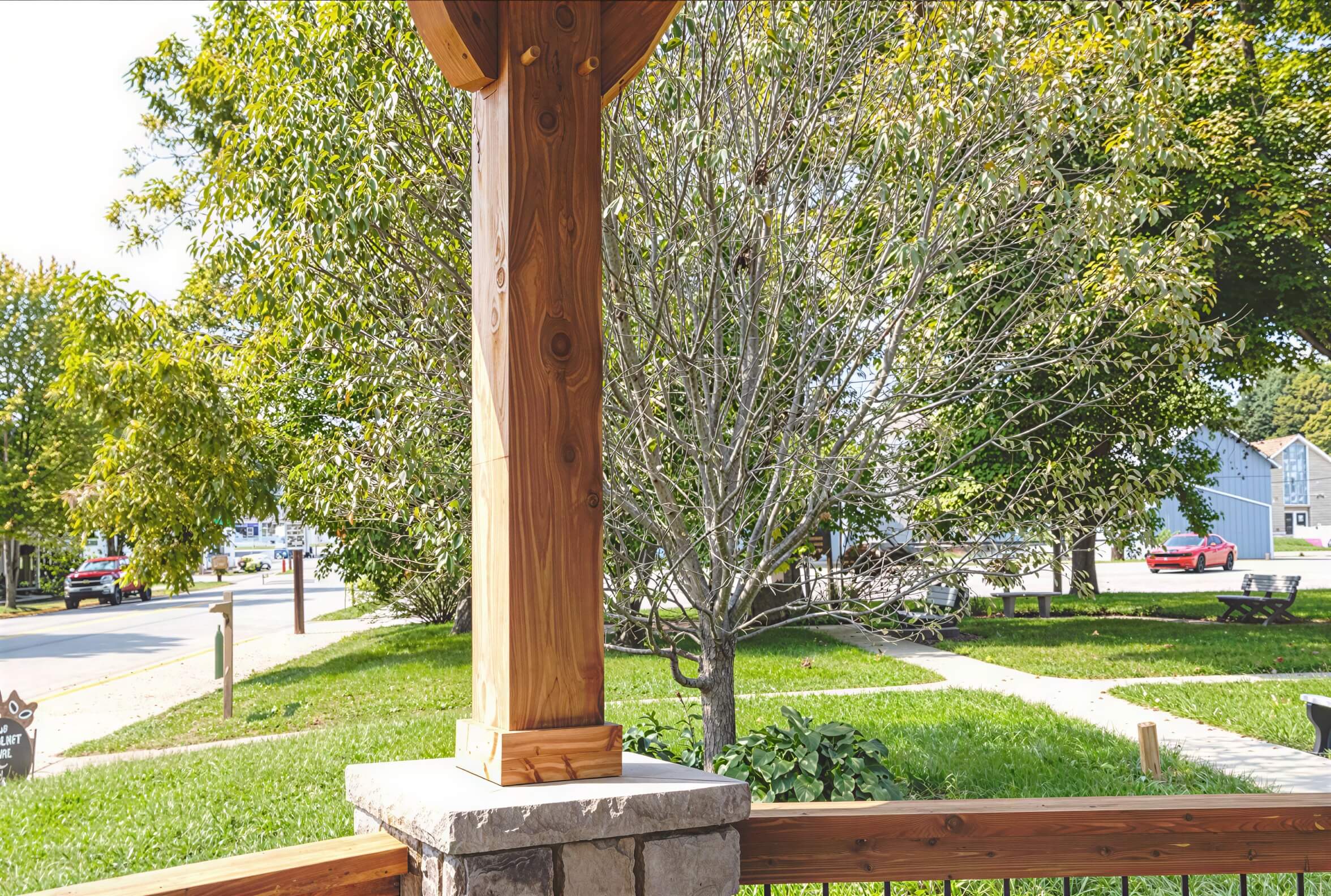 Brookside Timber Frame Lakeside Majestic Pavilion interior view showing a wood post on a stone base with outdoor scenery