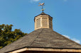 Brookside Timber Frame Lakeside Majestic Pavilion roof peak with cupola and weather vane against blue sky