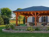 Brookside Timber Frame Timber Crest Pavilion is shown from the side with outdoor seating, landscaped greenery, and an open view of a peaceful yard