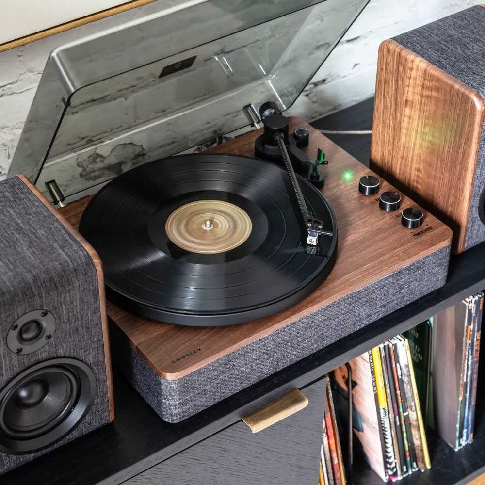 Captured from a top view, the Crosley Nocturne Record Player With Speakers - Charcoal highlights its wooden base, charcoal fabric finish, and matching speakers