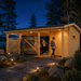 Brightly illuminated Carport Hugo 44 at night near Lake Tahoe as adults arrive home and unload a vehicle behind the slatted screen.
