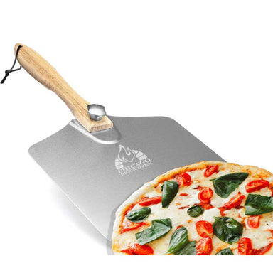 Chicago Brick Oven 12 x 14 Aluminum Pizza Peel with Foldable Wooden Handle in use, showing a pizza resting on its sleek aluminum peel surface