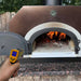 Chicago Brick Oven Infrared Thermometer Gun being used to measure the temperature of a wood-fired oven