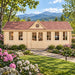 Straight-on view of the Clockhouse Bristol 44mm Freedom House in western North Carolina, surrounded by flowering rhododendrons and the Blue Ridge Mountains, with adults working inside a bright professional office.