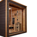 Close angled view of Golden Designs Visby 3 Person Outdoor-Indoor PureTech Hybrid Full Spectrum Sauna with a guarded stove and lit cedar bench visible through the glass front