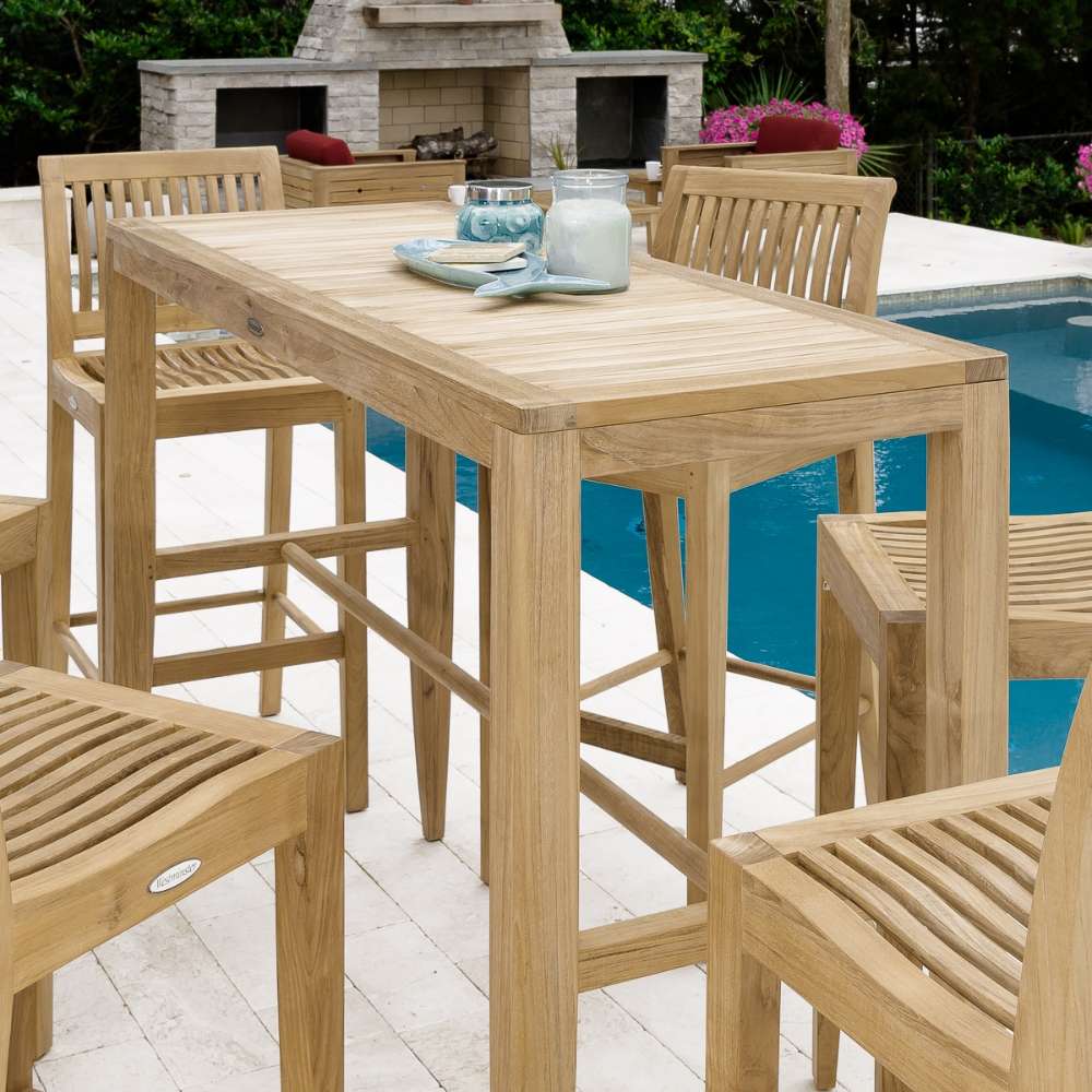 Close outdoor styling of Westminster Teak 5ft Laguna Teak Bar Table with simple decor near a poolside setting