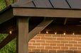 Close-up of Brookside Timber Frame Stonewood Pavilion highlights its sturdy wooden post, angled support beams, and string lights beneath the roof