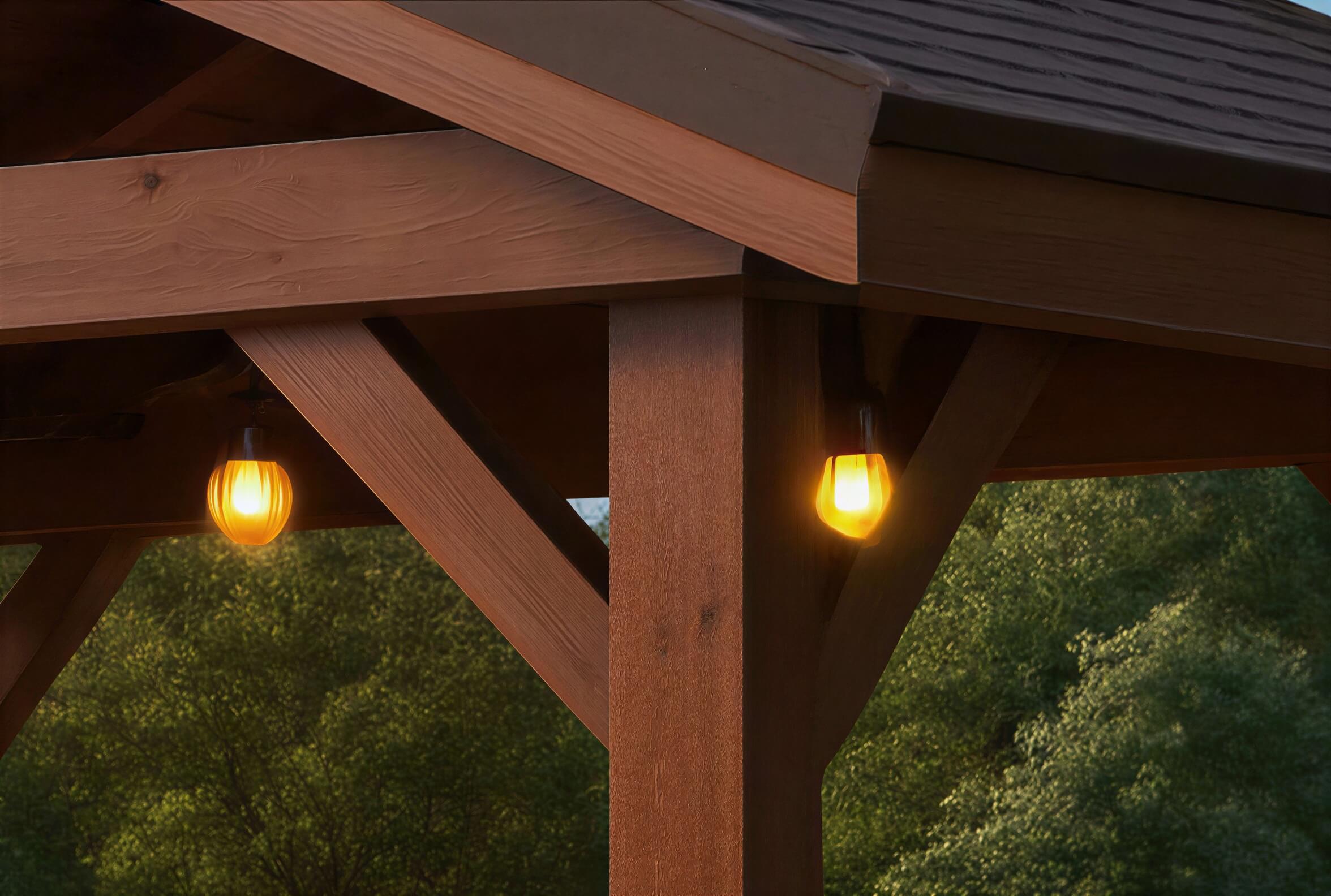 Close-up of Brookside Timber Frame Veranda Pavilion highlights its wooden beams and a warm hanging light fixture