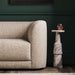 Close-up of Crate & Barrel Contour Sofa arm beside a marble side table with a glass of rosé in a stylish living room
