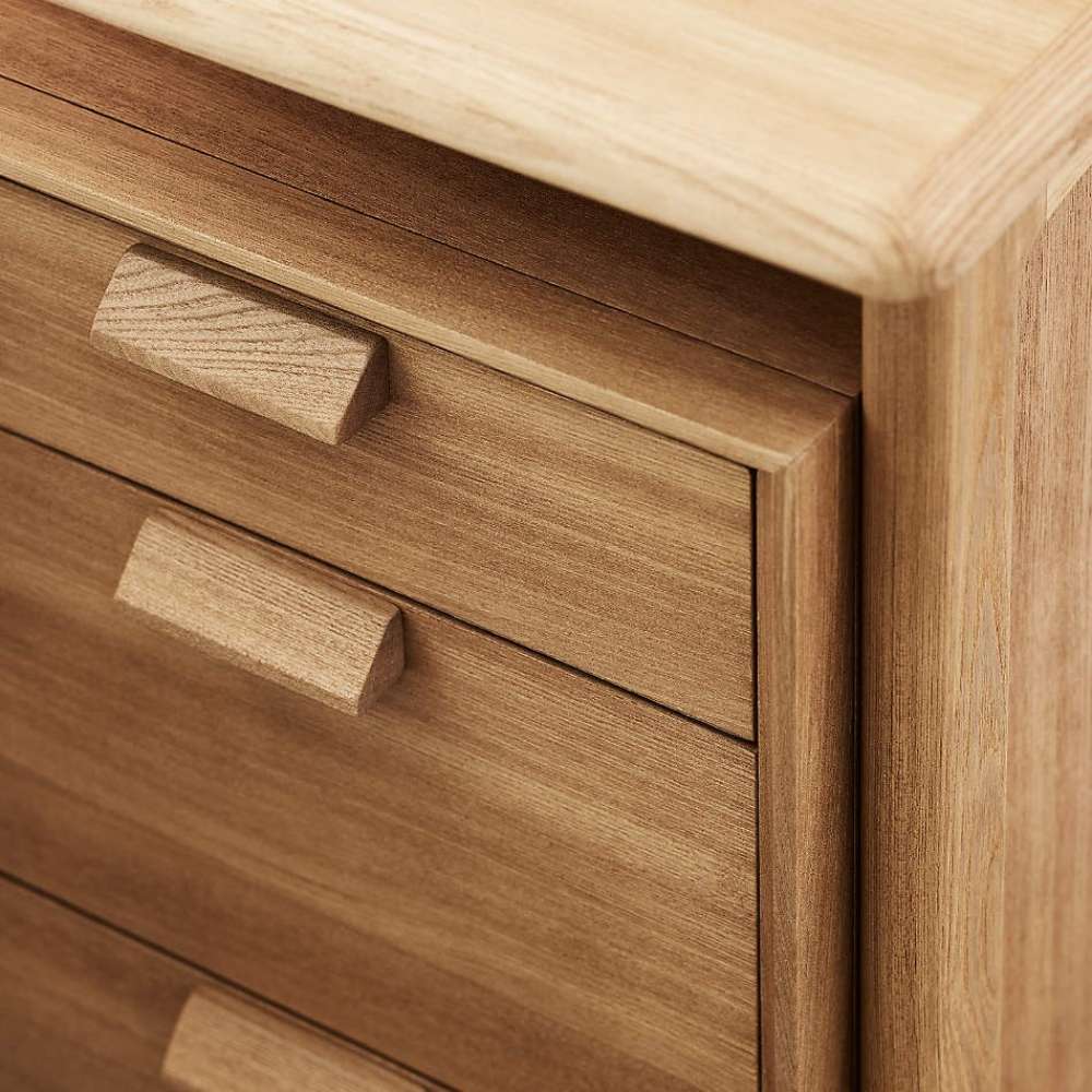Close-up of Crate & Barrel Elias 66" Natural Elm Wood Desk with File Cabinet showcases its natural elm wood grain and clean-lined drawer pulls