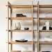 Close-up of Crate & Barrel Elias Natural Elm Wood Open Bookcase displaying decorative vases, books, and bowls on its smooth natural wood shelves