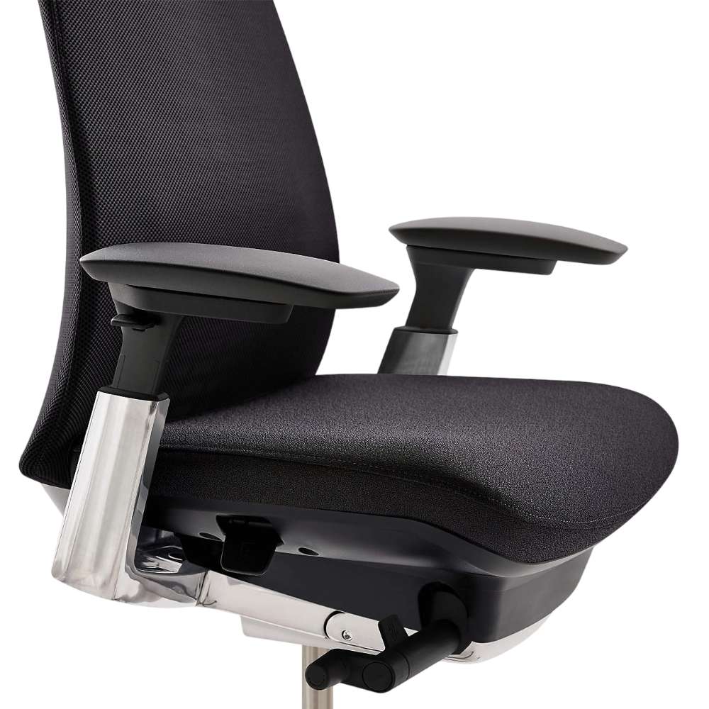 Close-up of Crate & Barrel Haworth Fern Upholstered Coal Office Chair seat, adjustable armrests, and under-seat adjustment controls