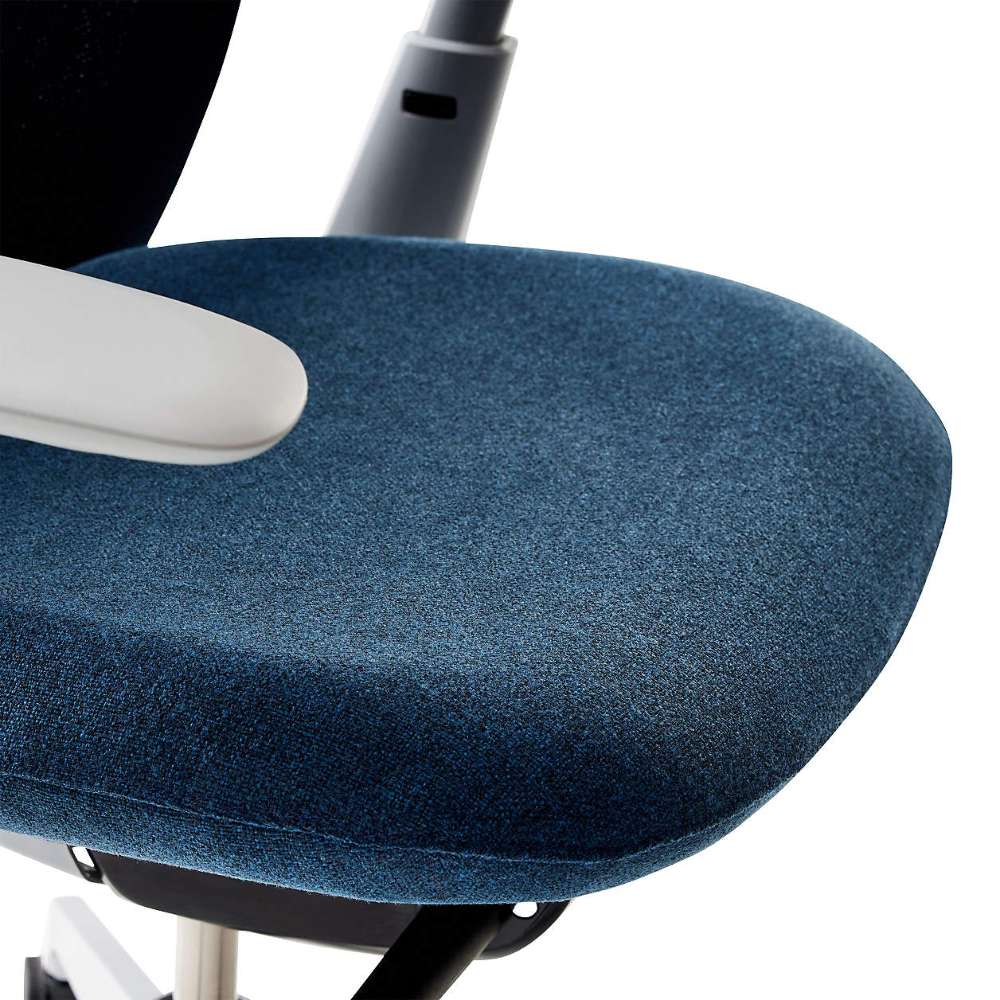 Close-up of Crate & Barrel Haworth Soji Upholstered Navy and Mesh Office Chair showcases the plush navy upholstered seat with rounded edges