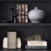 Close-up of Crate & Barrel Keane 40" Black Wood Storage Bookcase, Set of 2 styled with books, pottery, and decorative accents