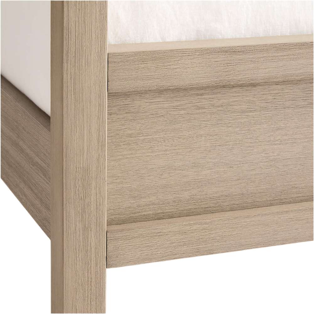 Close-up of Crate & Barrel Keane Weathered Natural Solid Wood King Canopy Bed highlights the solid wood footboard corner with a weathered natural finish