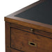 Close-up of Crate & Barrel Morris 72" Chocolate Brown Writing Desk highlighting the black writing surface, wood grain, and drawer hardware