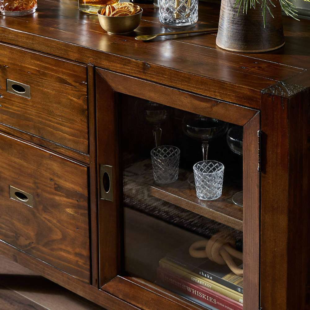 Close-up of Crate & Barrel Morris Chocolate Brown Credenza showing a glass-door cabinet, wood drawers, and rich brown finish