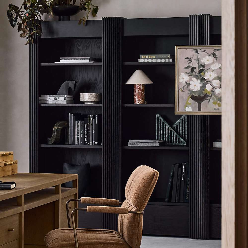 Close-up of Crate & Barrel Siena 34" Black Wood 4-Shelf Storage Bookcase with Drawer displaying books artwork and decorative accents