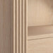 Close-up of Crate & Barrel Siena 34" Whitewash Wood 4-Shelf Storage Bookcase with Drawer highlighting the whitewash wood grain and fluted accents