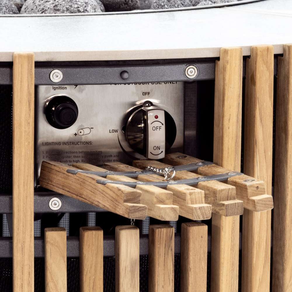 Close-up of Westminster Teak Agora Fire Table highlights the ignition control knob behind the slatted teak exterior