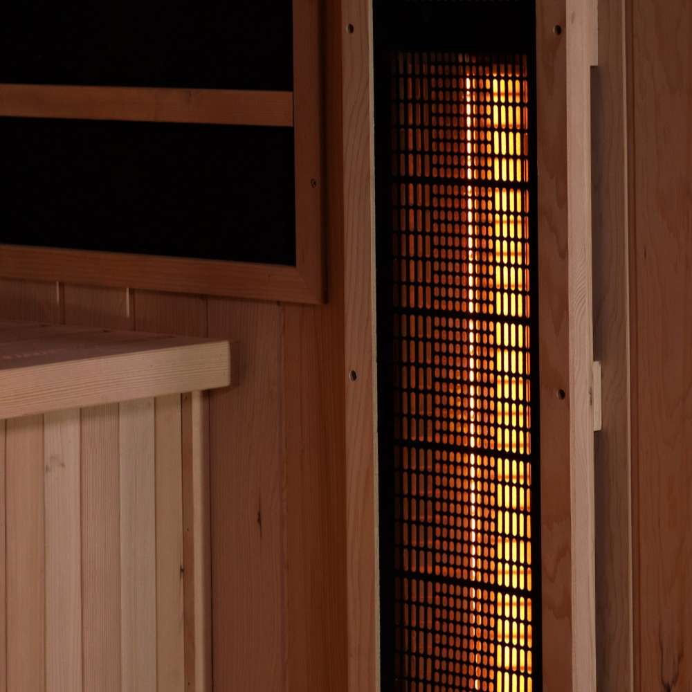 Close-up of a near infrared heater glowing behind a wood grille on the side wall of Golden Designs Reserve Edition 4 Person Full Spectrum Sauna with Himalayan Salt Bar