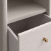 Close-up of an empty open drawer on Crate & Barrel Lafayette 64" Whitewashed Desk with Outlets with a gold knob
