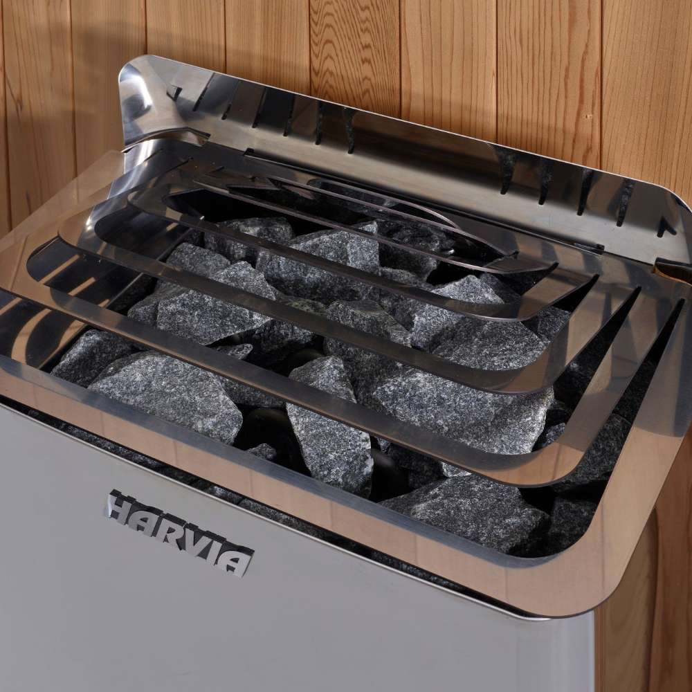Close-up of gray sauna stones under steel guard rails on top of the Harvia stove in Golden Designs Carinthia 3 Person Hybrid Outdoor Sauna