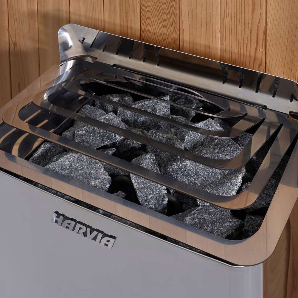 Close-up of gray sauna stones under steel guard rails on top of the Harvia stove in Golden Designs Gargellen 5 Person Hybrid Outdoor Sauna
