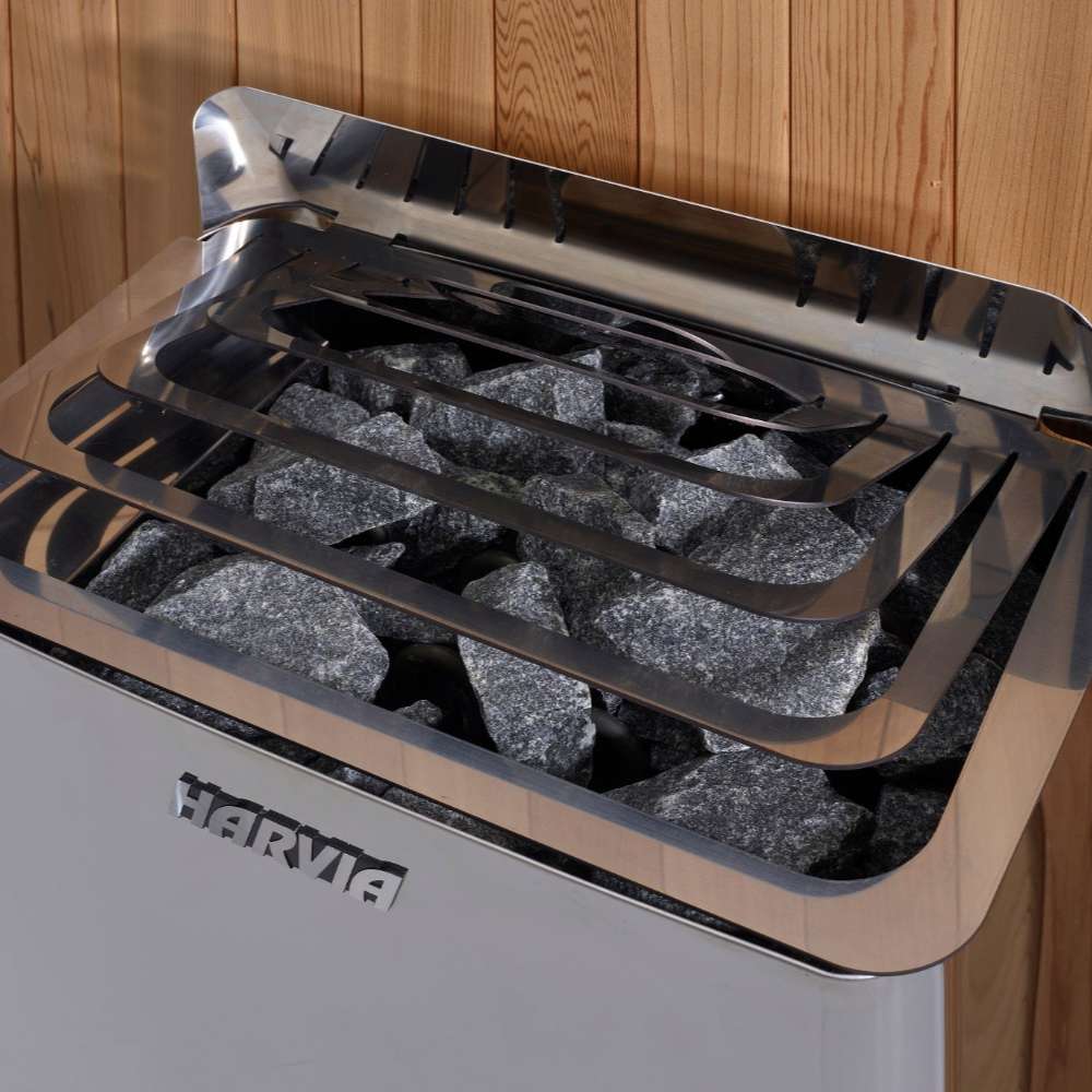 Close-up of gray sauna stones under steel guard rails on top of the Harvia stove in Golden Designs St. Moritz 2 Person Barrel Traditional Sauna