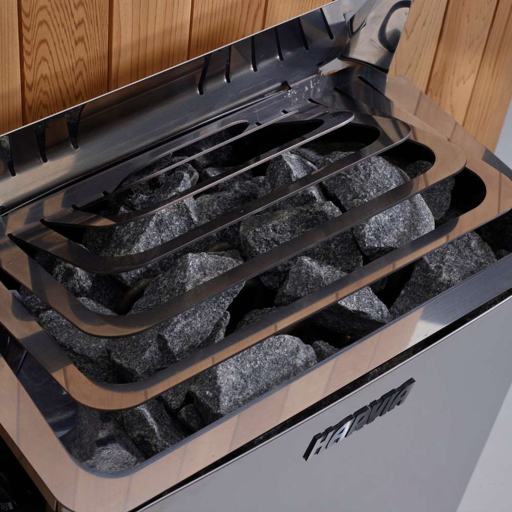 Close-up of gray sauna stones under steel guard rails on top of the Harvia stove in Golden Designs Toledo 6 Person Indoor Hybrid Sauna with Full Spectrum IR and Harvia Stove