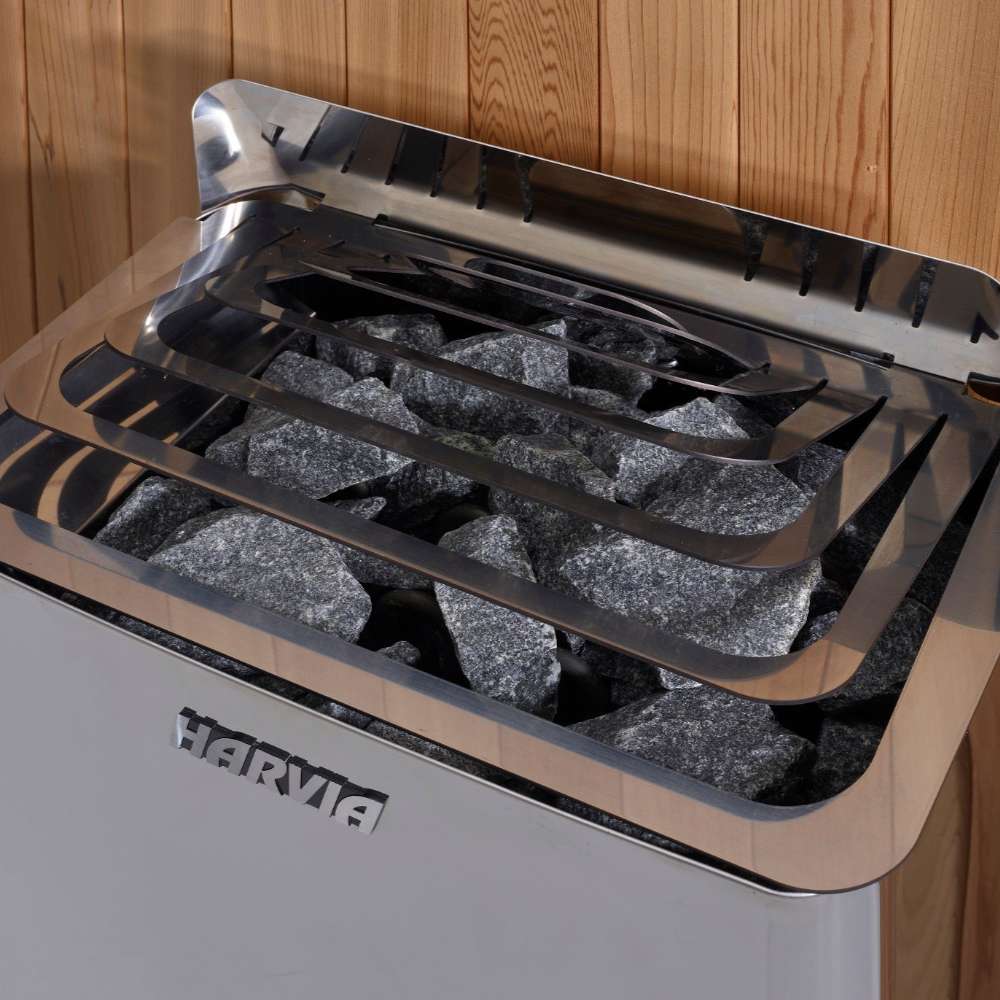 Close-up of gray sauna stones under steel guard rails on top of the Harvia stove in Golden Designs Vorarlberg 5 Person Traditional Outdoor Sauna