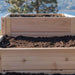 Close-up of soil inside a wooden planter focuses on the Outdoor Living Today 5.5×2 Tiered Cedar L-Shaped Raised Garden Bed
