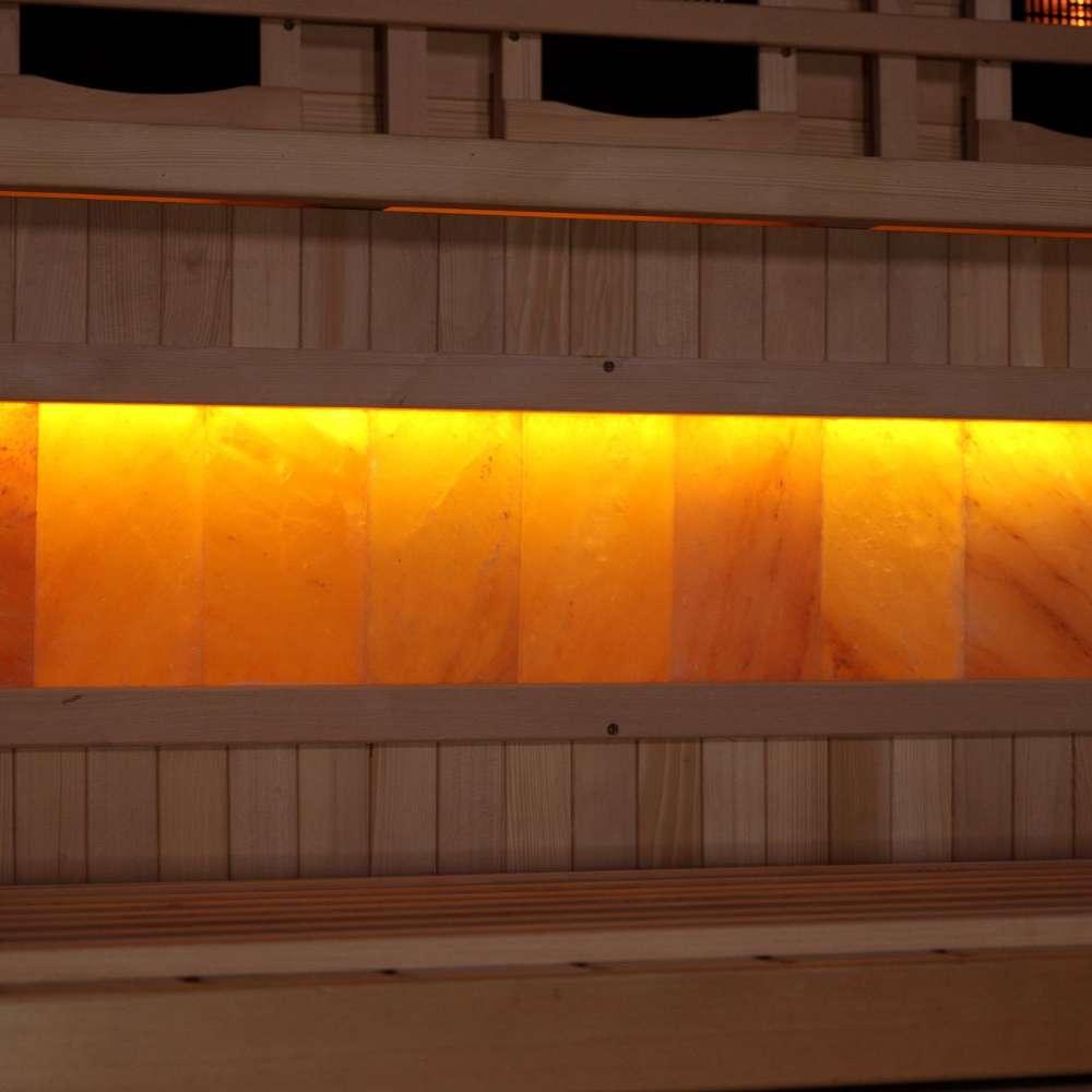 Close-up of the Himalayan salt bar in Golden Designs Reserve Edition 3 Person Full Spectrum Sauna with Himalayan Salt Bar, a row of glowing amber salt blocks below a wood bench