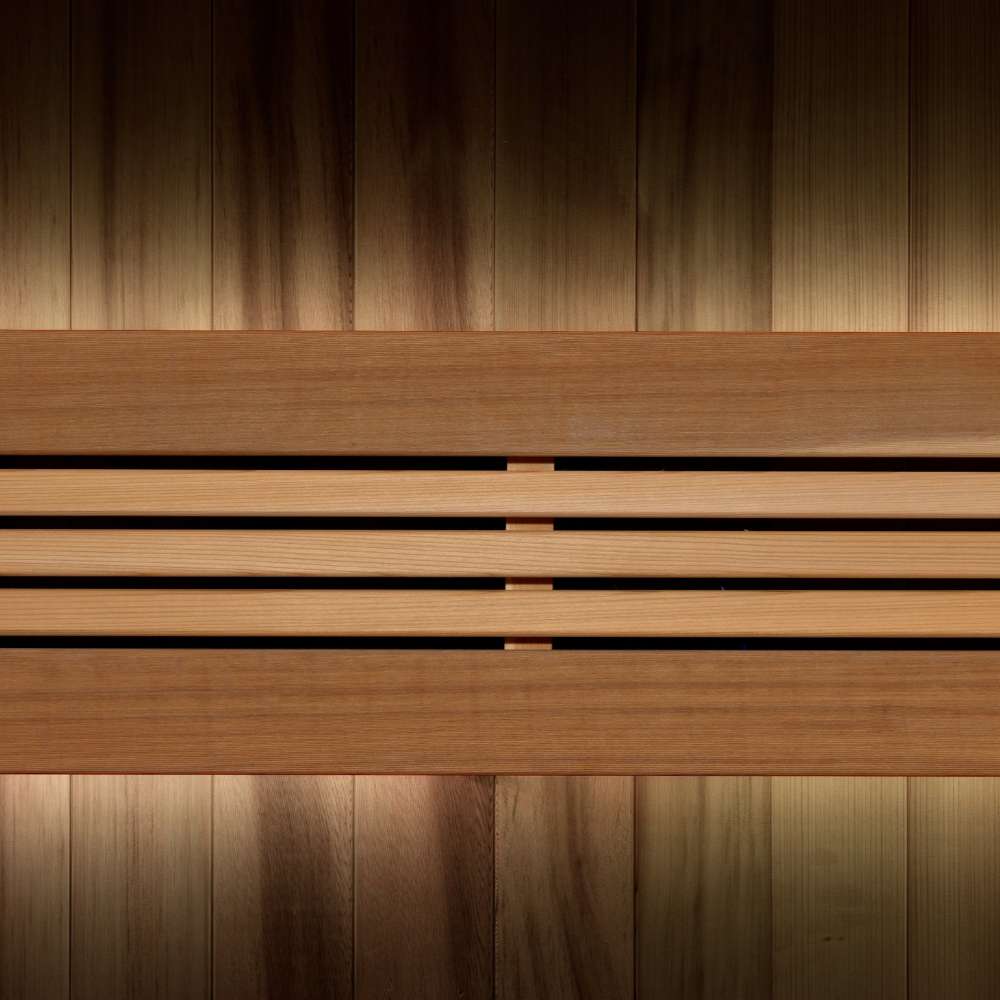 Close-up of the backrest in Golden Designs Osla 6 Person Traditional Sauna, where warm accent light glows behind horizontal cedar slats