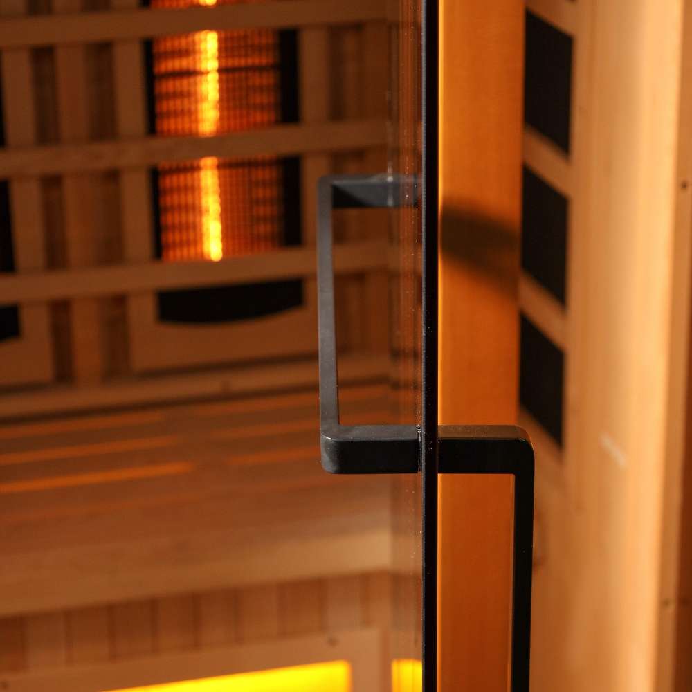 Close-up of the black finish door handle on the glass door of Golden Designs 2025 Reserve Edition 3 Person Full Spectrum Sauna with Himalayan Salt Bar, with amber light inside